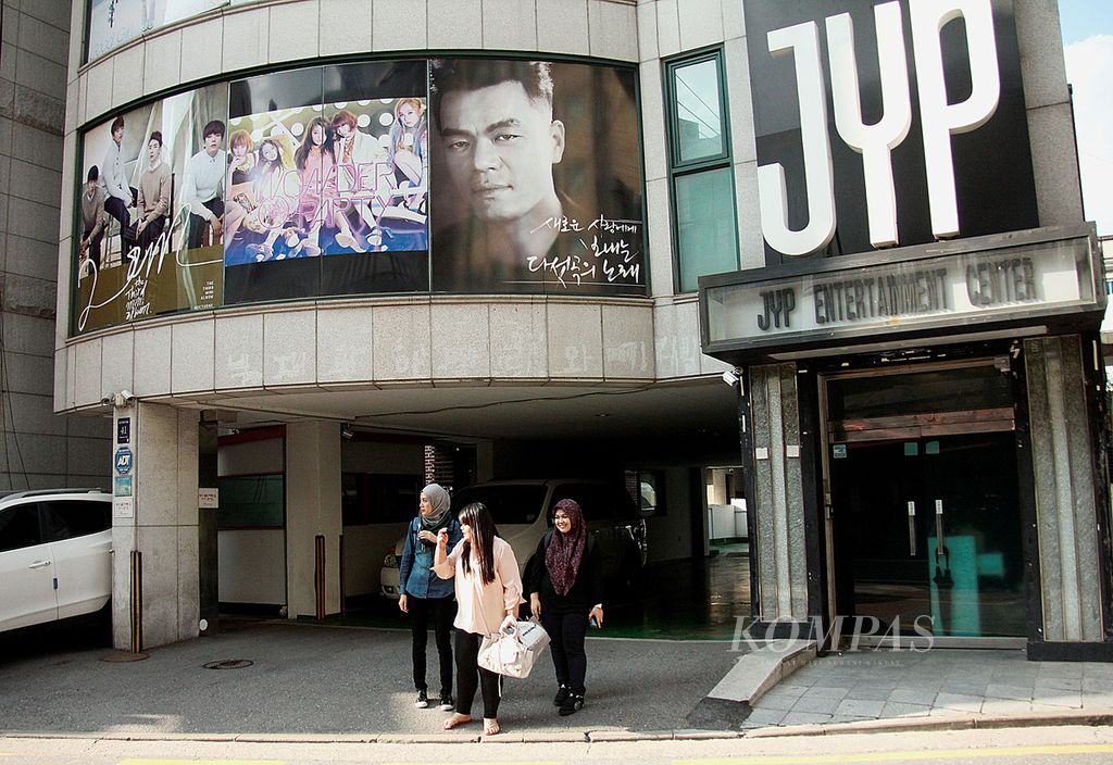 Tiga turis Malaysia berdiri di depan kantor manajemen artis terkenal Korea Selatan, JYP, di Seoul, Kamis (4/9/2014). Mereka mengaku berwisata ke Korsel karena K-Pop.