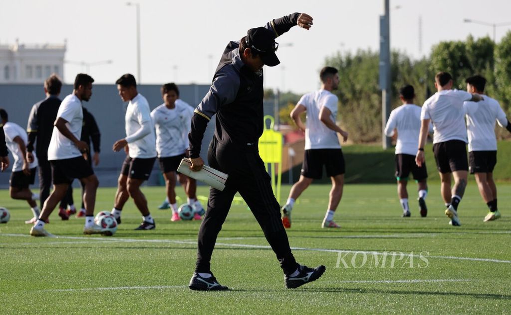 Pelatih Indonesia Shin Tae-yong melakukan peregangan saat mengawasi pemainnya berlatih di lapangan Al Egla Training Facility, di Lusail, Qatar, Jumat (26/1/2024). 