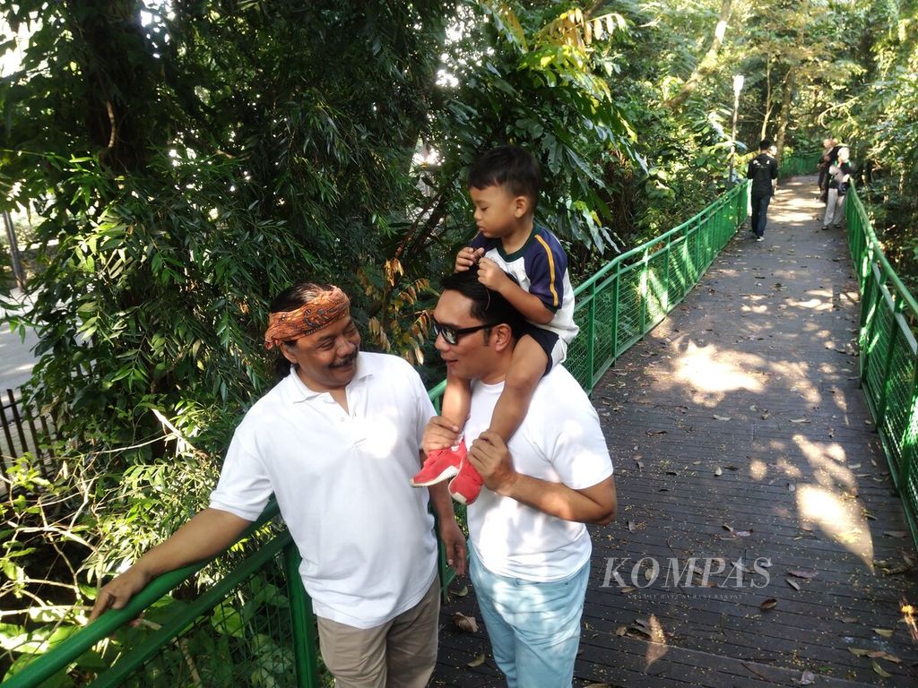 Gubernur Jawa Barat Ridwan Kamil bersama anaknya, Arkana Aidan Misbach, bertemu budayawan Iman Soleh di Forest Walk Babakan Siliwangi, Kota Bandung, Jabar, Rabu (10/5/2023). Babakan Siliwangi menjadi taman kota paling vital di Kota Bandung.