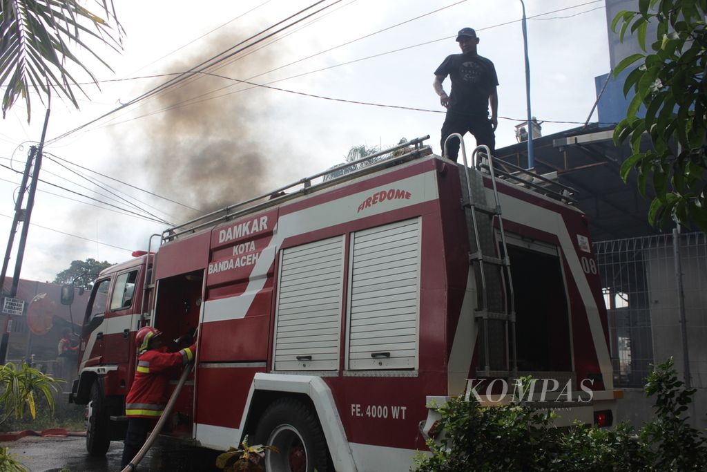 Petugas berusaha memadamkan api yang membakar gedung Suzuya Mall di Banda Aceh, Aceh, Senin (4/4/2022). Petugas kewalahan memadamkan api karena api berkobar cepat, sementara peralatan petugas terbatas.