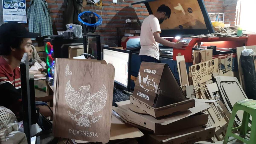 Pekerja tengah mendesain gambar Burung Garuda dan peta Indonesia di di bengkel kerja Hucravindo, salah satu Industri kecil menengah kerajinan kayu di Sidoarjo, Jawa Timur, Senin (7/11/2022). Industri milik Muhammad Aliyafi (29) ini terpilih sebagai salah satu souvenir resmi KTT G20 di Bali tahun ini. 