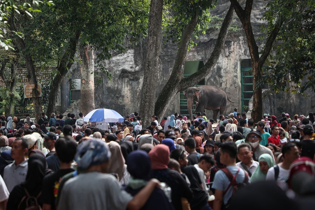 Kerumunan pengunjung di sekitar kandang gajah di Kebun Binatang Ragunan, Jakarta, Senin (24/4/2023). Warga memanfaatkan libur cuti bersama Lebaran untuk berekreasi ke berbagai tempat wisata, salah satunya Kebun Binatang Ragunan. Dengan harga tiket yang murah, pengunjung dapat bersantai dan berkeliling untuk melihat dan mengenalkan berbagai satwa kepada anak-anak. ADRYAN YOGA PARAMADWYA (Z20) 24-04-2023