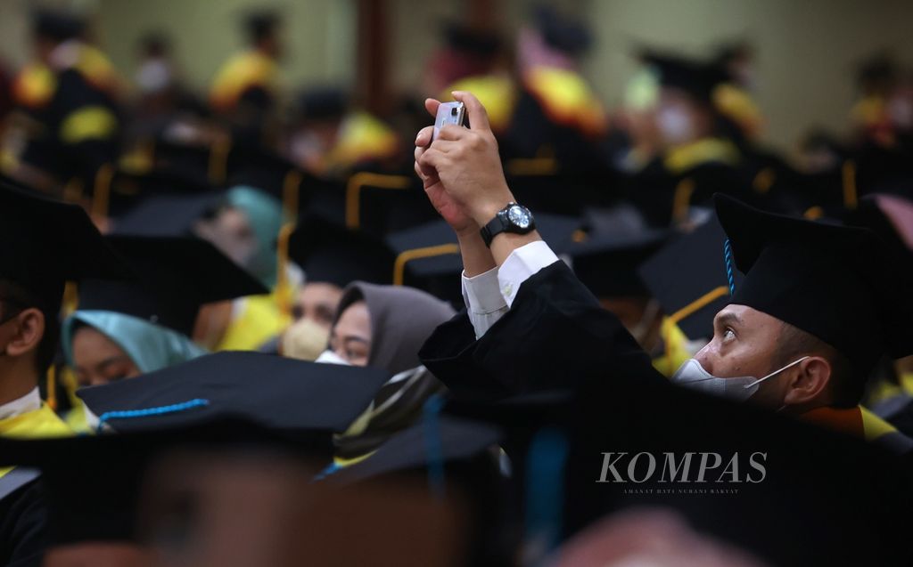 Wisudawan mengabadikan wisuda di Universitas Terbuka di kampus UT, Tangerang Selatan, Banten, Selasa (23/8/2022).