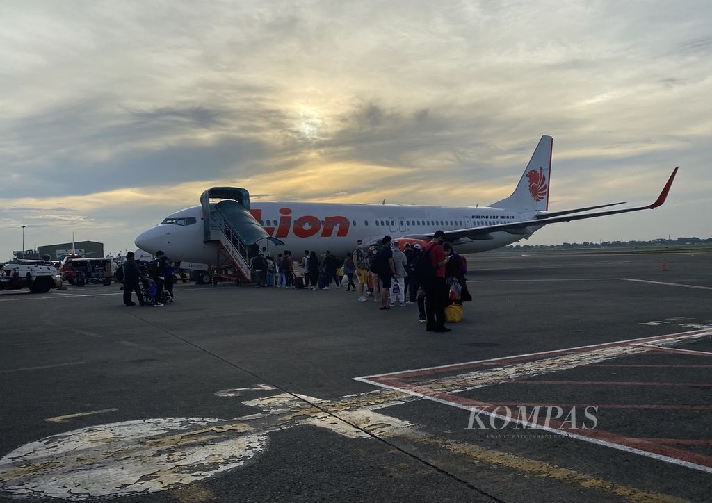 Penumpang mengantre masuk ke dalam pesawat di Bandara Internasional Soekarno-Hatta, Tangerang, Banten, pada Sabtu (19/3/2022). Seiring dengan adanya pelonggaran aturan perjalanan, aktivitas penumpang di bandara tersebut menggeliat. 