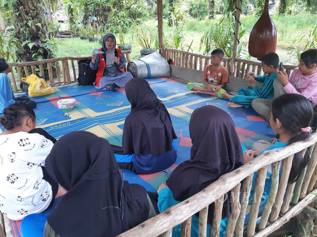 Pendongeng dan aktivis disabilitas Detty Herawaty berdongeng untuk anak-anak di Taman Baco Atap Rumbe, Desa Jambi Tulo, Muaro Jambi, November 2022.
