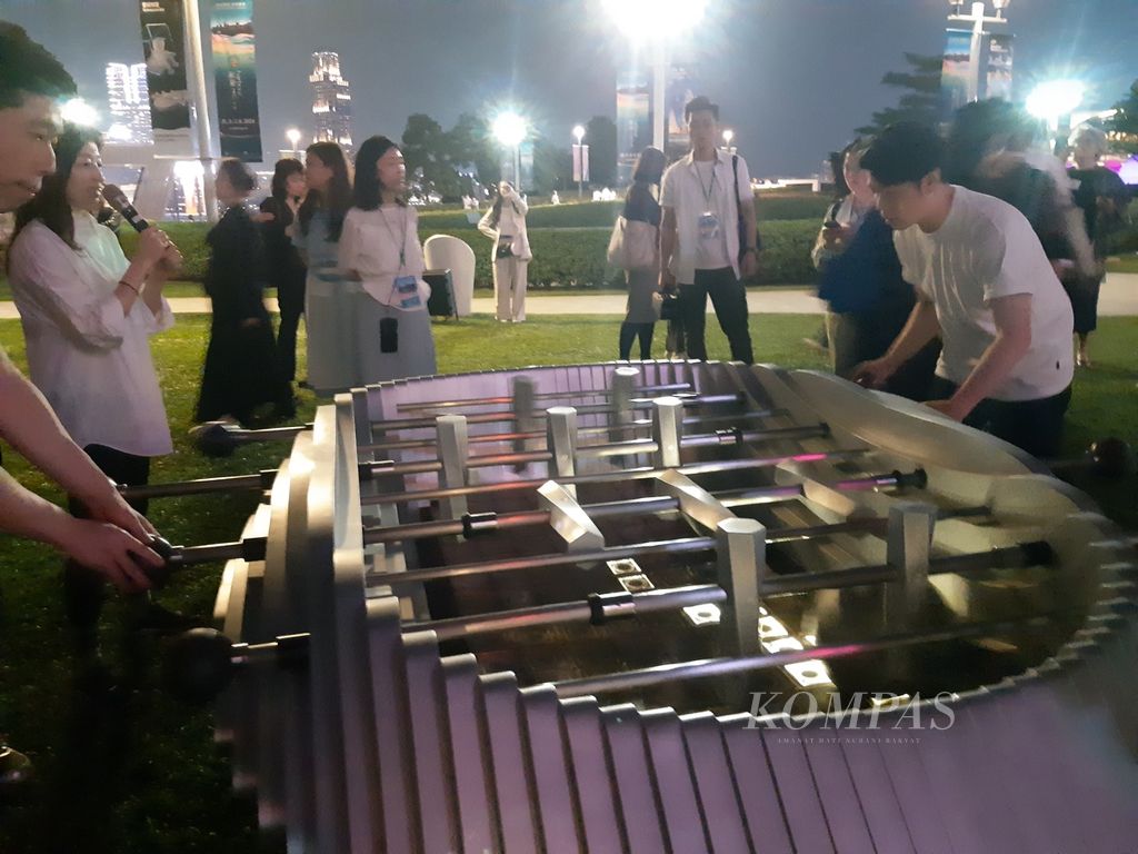 Sejumlah pengunjung memainkan Cup Habour, permainan seperti sepak bola meja, di Taman Tamar, di kota Hong Kong, Selasa (26/3/2024). Ini menjadi salah satu daya tarik wisata. 
