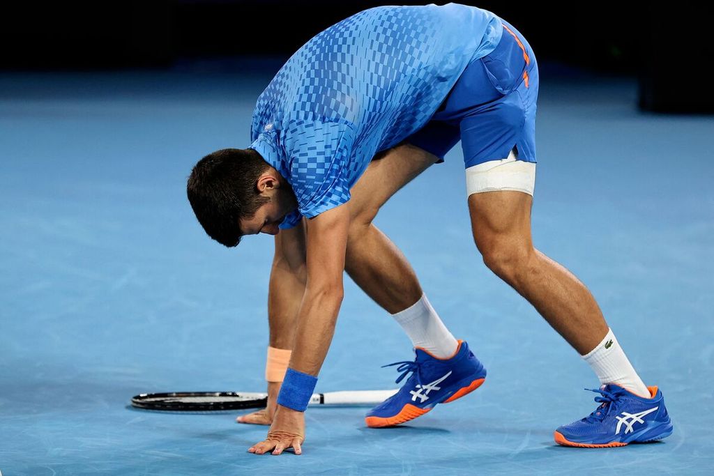 Novak Djokovic dengan paha kiri terbebat menahan gerakan saat melawan petenis Bulgaria, Grigor Dimitrov, pada babak ketiga Grand Slam Australia Terbuka di Melbourne, 21 Januari 2023. 