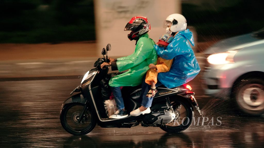 Pemudik sepeda motor menembus hujan di perbatasan Jakarta-Bekasi di Jalan Kalimalang, Jakarta Timur, Rabu (27/4/2022). 
