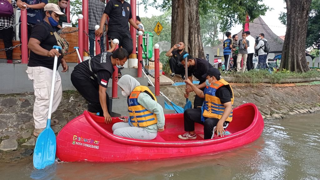 Tim Brigade 1016 atau petugas taman dari Dinas Kebudayaan dan Pariwisata Kota Tangerang membantu warga menjajal wisata kano di Kali Sipon, Kota Tangerang, Banten, Sabtu (20/8/2022).