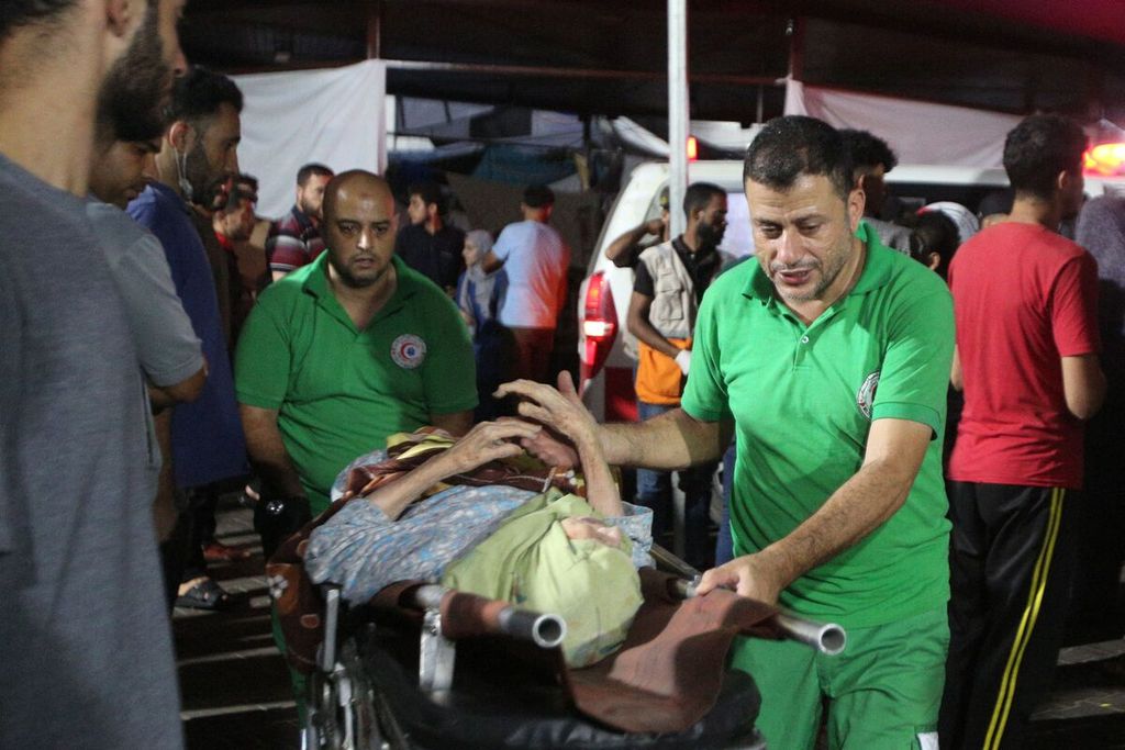 Petugas medis membawa seorang perempuan terluka di tengah pertempuran Hamas dan Israel ke Rumah Sakit Al-Shifa di kota Gaza, 6 November 2023. 