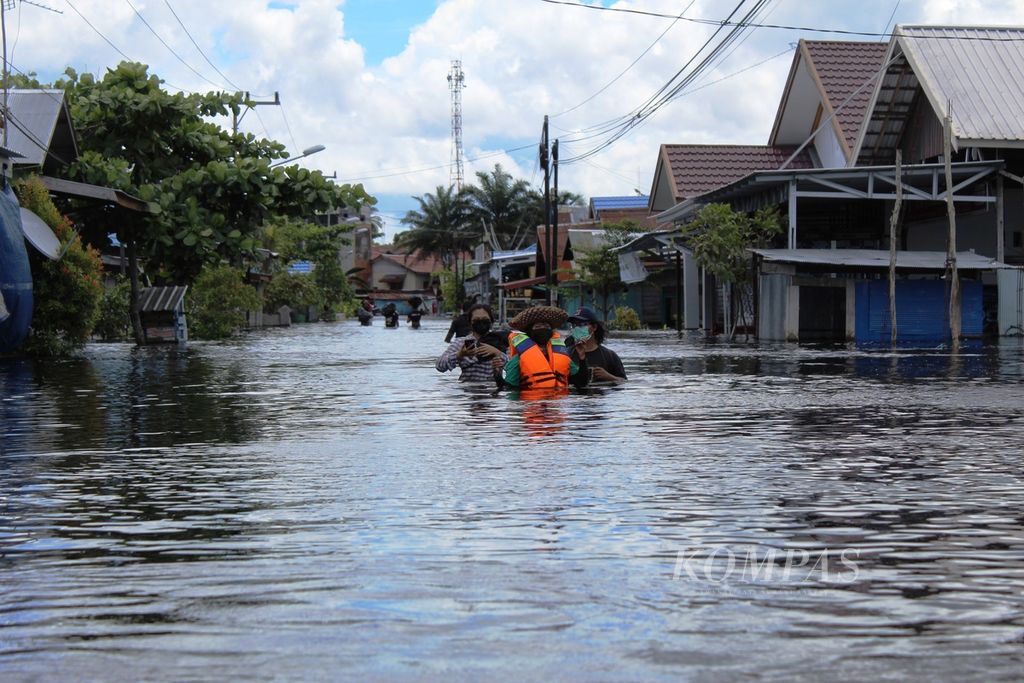 Sukarelawan banjir Kota Palangkaraya memasuki wilayah banjir di Jalan Arut, Kelurahan Palangka, Kota Palangkaraya, Kalimantan Tengah, Kamis (18/11/2021). Setidaknya 17 kelurahan di Palangkaraya terendam banjir.
