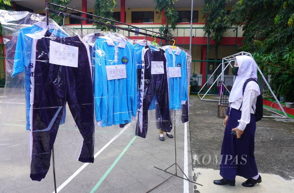 Siswa sedang memilih ukuran seragam olahraga di halaman SMA Negeri 1 Slawi, Kabupaten Tegal, Jawa Tengah, Senin (13/7/2020). Dalam kegiatan masa pengenalan lingkungan sekolah (MPLS), siswa juga diminta menentukan ukuran seragam olahragnya masing-masing.