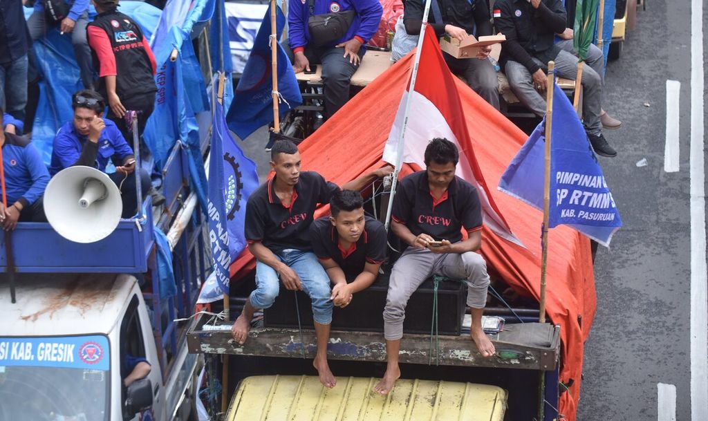 Buruh yang berunjuk rasa bergerak menuju Gedung Grahadi setelah sempat menutup Jalan Basuki Rahmat, Kota Surabaya, Jawa Timur, Rabu (1/3/2022). Kemacetan lalu lintas tidak bisa dihindari akibat massa menutup sejumlah jalan utama menuju Gedung Grahadi.