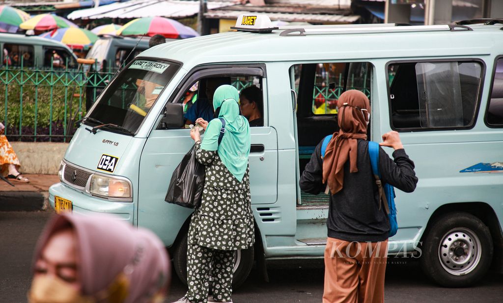 Penumpang membayar ongkos saat turun dari mikrolet di dekat Stasiun Tanah Abang, Jakarta Pusat, Senin (5/9/2022).