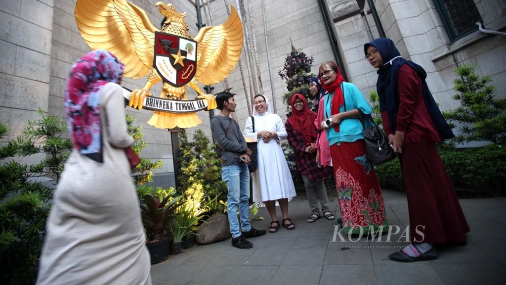Umat lintas agama berbincang di patung Garuda Pancasila di Gereja Katedral, Jakarta, saat kumpul menjelang buka bersama lintas agama dengan tema Menguatkan Toleransi, Persaudaraan, dan Solidaritas Kemanusiaan, Jumat (1/6/2018).