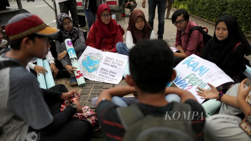 Sejumlah remaja menggelar aksi damai tentang bahaya bencana perubahan iklim di depan Gedung Balai Kota DKI Jakarta, Jumat (15/3/2019). Aksi mereka itu terinspirasi dari gerakan yang dilakukan oleh aktivis remaja asal Swedia, Greta Thunberg.