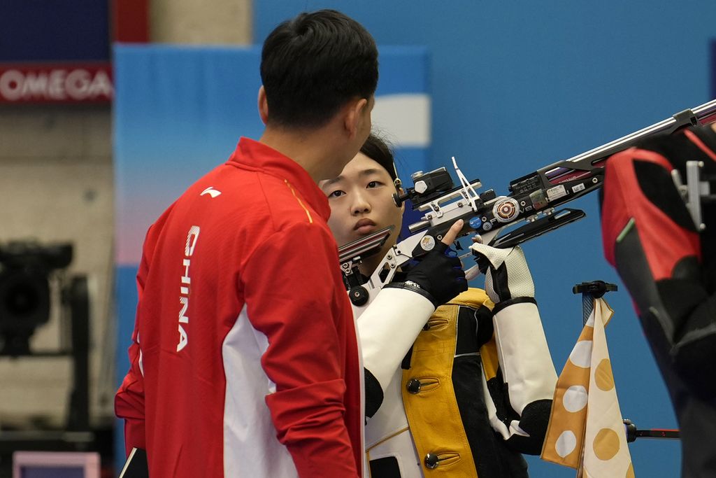 Atlet menembak China, Huang Yuting, berbicara dengan pelatihnya saat berlompa pada nomor 10 meter <i>air rifle</i> campuran di Olimpiade Paris 2024, Sabtu (27/7/2024).