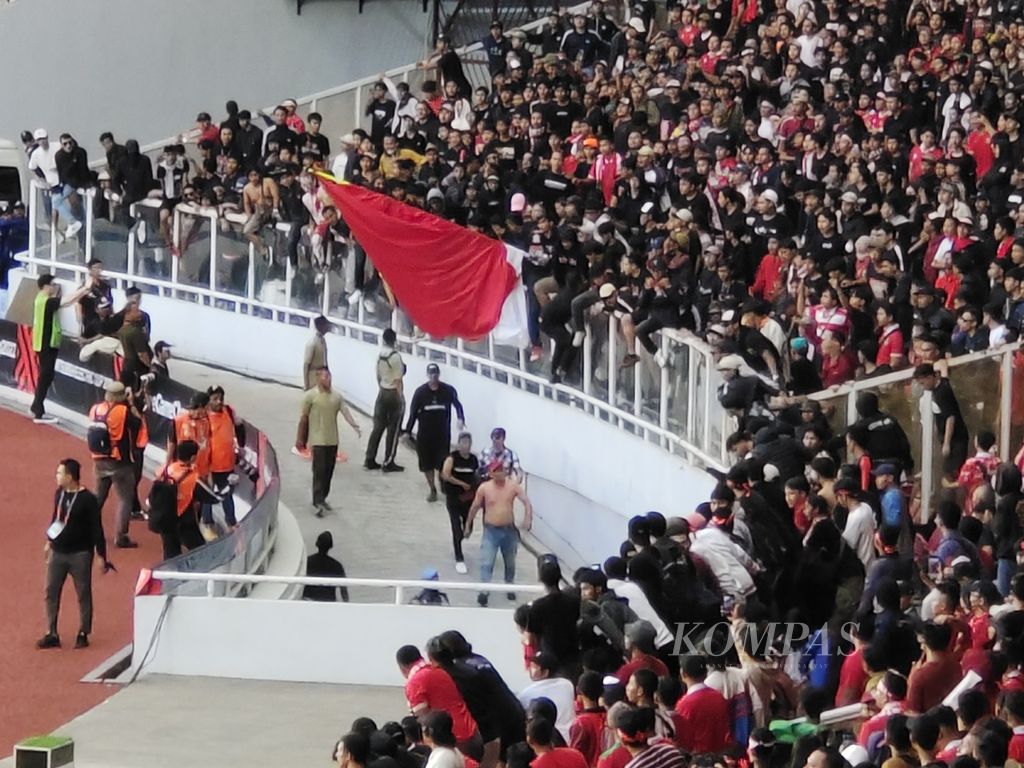 Kelompok suporter Ultras Garuda yang turun ke lapangan usai insiden dengan petugas keamanan di salah satu tribune belakang gawang Stadion Gelora Bung Karno, Jakarta saat laga Piala AFF 2022 antara Indonesia dan Kamboja, Jumat (23/12/2022). 