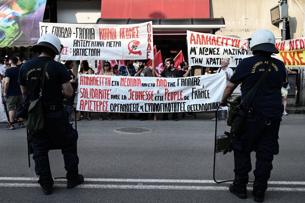 Para pengunjukrasa memegang spanduk di luar Institut dan Konsulat Perancis, di Thessaloniki pada 3 Juli 2023, saat aksi protes setelah Nahel tewas ditembak polisi. 