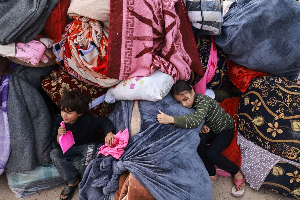 Anak-anak beristirahat di atas selimut ketika pengungsi Palestina dari Gaza tengah dan selatan mendirikan tenda di kamp baru Tall el-Sultan, di sebelah barat Rafah, Jalur Gaza selatan, Minggu (3/12/2023).