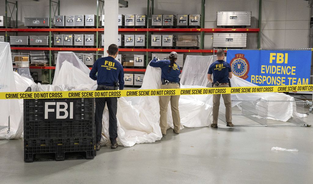 Dalam gambar yang disediakan oleh FBI, agen khusus FBI memeriksa materi yang diambil dari balon yang ditemukan di lepas pantai Carolina Selatan, Kamis (9/2/2023), di laboratorium FBI di Quantico, Virginia, AS.  