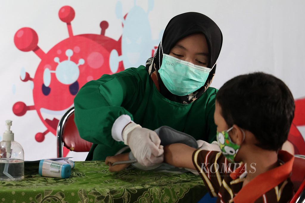 Petugas mengukur tekanan darah murid yang akan mendapat suntikan vaksin Covid-19 di SD Masjid Syuhada, Gondokusuman, Yogyakarta, Selasa (8/2/2022). 