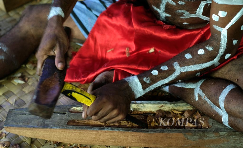 Pengukir suku Kamoro sedang mengukir kayu di Kampung Nawaripi, Distrik Wania, Kabupaten Mimika, Jumat (18/3/2022).  