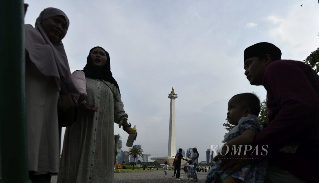 Pengunjung menikmati suasana saat berlibur di kawasan Monumen Nasional (Monas), Jakarta, Minggu (26/6/2022). Sejak kembali dibuka untuk umum dan wisatawan pada pekan lalu, animo pengunjung untuk datang ke kawasan Monumen Nasional relatif tinggi. Pengunjung tidak hanya dari Jakarta saja namun banyak wisatawan yang datang dari sejumlah daerah. 