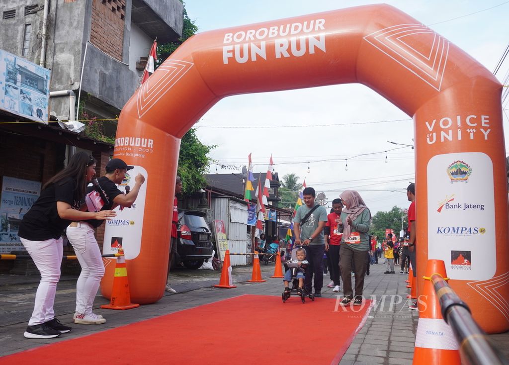 Pembawa acara menyambut peserta Borobudur Fun Run di garis finis di kompleks Candi Pawon, Borobudur, Kabupaten Magelang, Jawa Tengah, Minggu (3/12/2023).