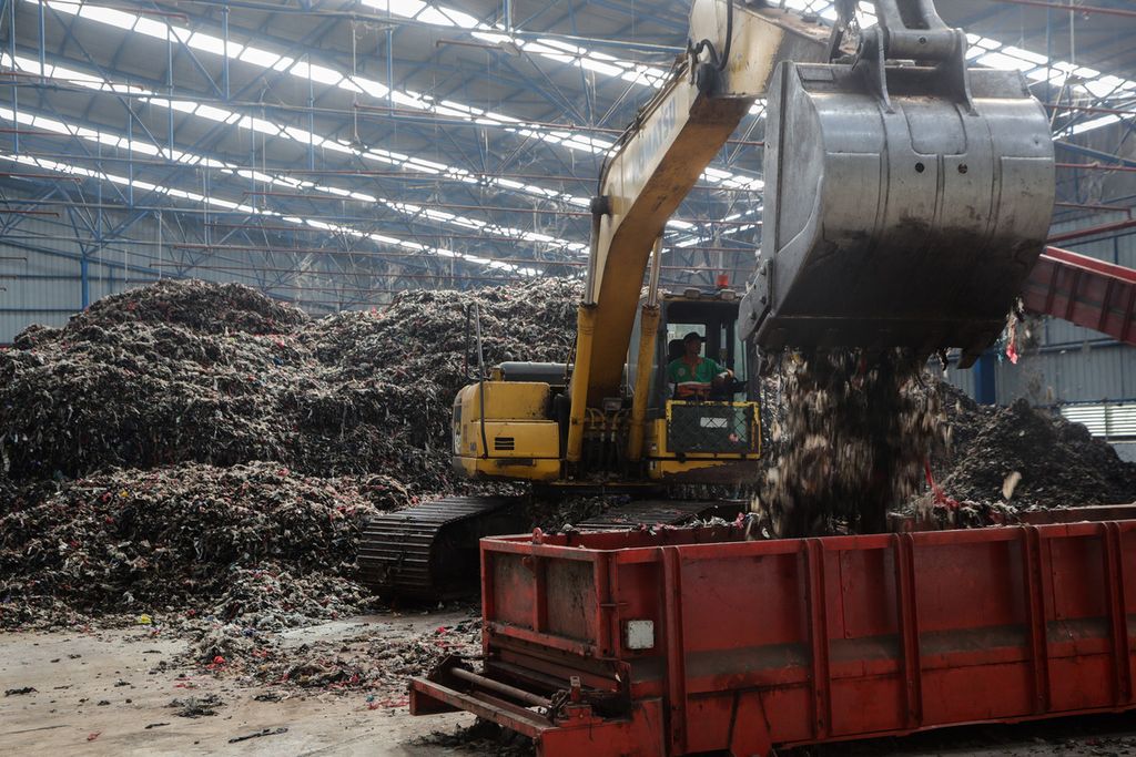 Ekskavator mengumpulkan bahan bakar sampah atau <i>refuse derived fuel </i>(RDF) yang siap dikirimkan di gudang penyimpanan di kawasan Fasilitas Landfill Mining dan Refuse Derived Fuel Plant TPST Bantargebang, Kota Bekasi, Selasa (27/6/2023). 