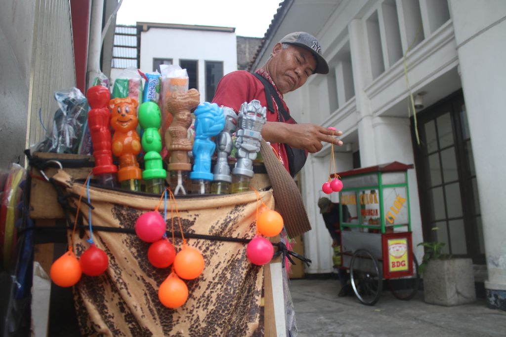 Penjual lato-lato memainkan mainan tersebut di sisi Jalan Naripan, Kota Bandung, Jawa Barat, Senin (16/1/2023). Penjualan dari lato-lato mampu menambah penghasilan para pedagang kaki lima sehingga membantu mata pencarian mereka.