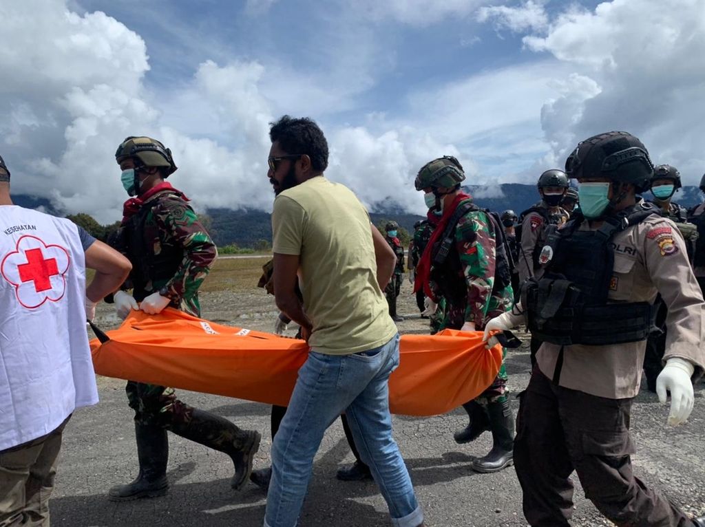 Tampak tim medis dan aparat keamanan membawa jenazah salah satu dari delapan korban serangan kelompok kriminal bersenjata saat tiba di Timika, Papua, dengan pesawat pada Senin (7/3/2022). Para korban tewas dalam serangan kelompok tersebut pada 2 Maret 2022.