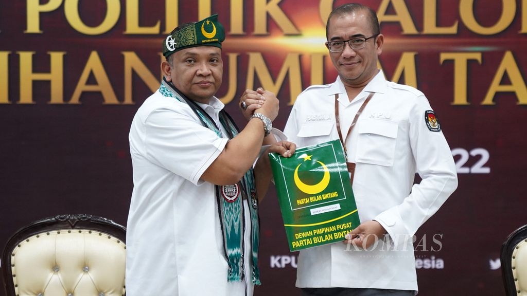 Sekertaris Jenderal Partai Bulan Bintang Afriansyah Noor (kiri) melakukan pendaftaran keikutsertaan Pemilu 2024 dan diterima oleh Ketua KPU Pusat Hasyim Asyari (kanan) di kantor KPU Pusat, Jakarta, Senin (1/8/2022). 