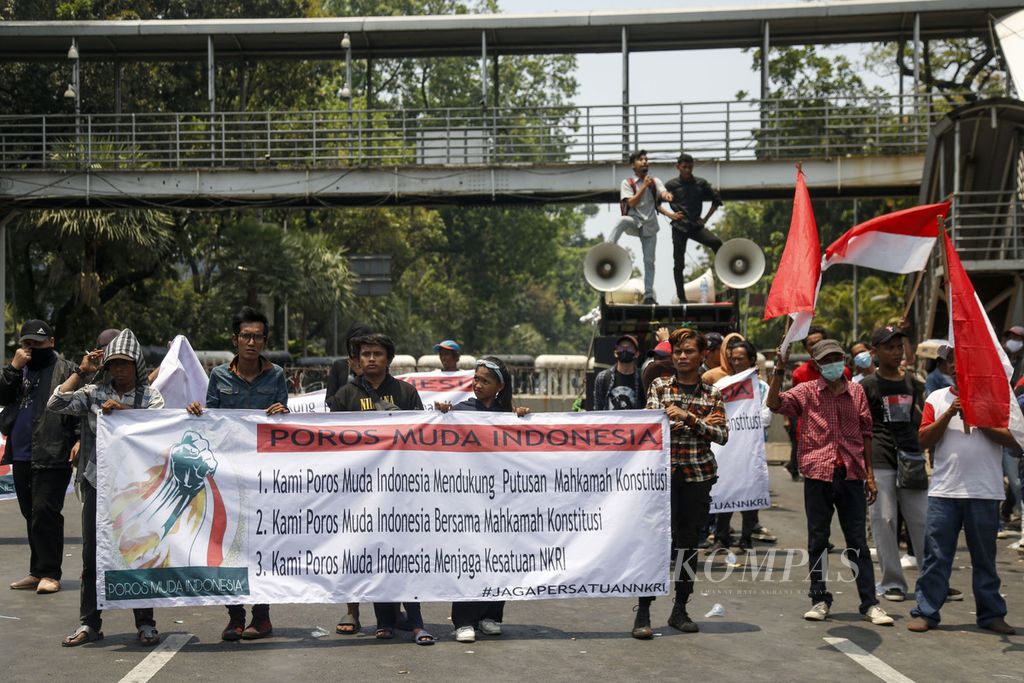 Peserta aksi membentangkan spanduk berisi dukungan kepada Mahkamah Konstitusi untuk mengabulkan permohonan gugatan syarat usia minimal calon presiden dan calon wakil presiden saat aksi di Patung Kuda Arjuna Wijaya, Jakarta, Senin (16/10/2023). 