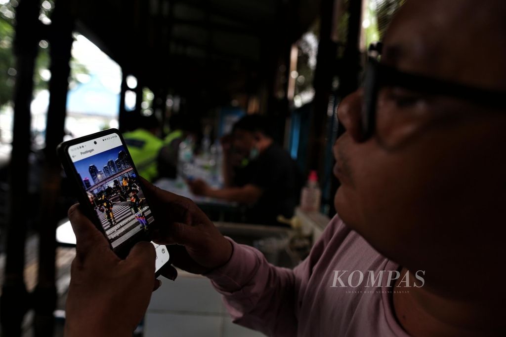 Warga menggunakan telepon pintarnya untuk memantau media sosial di kawasan Menteng, Jakarta, Jumat (10/6/2022). 