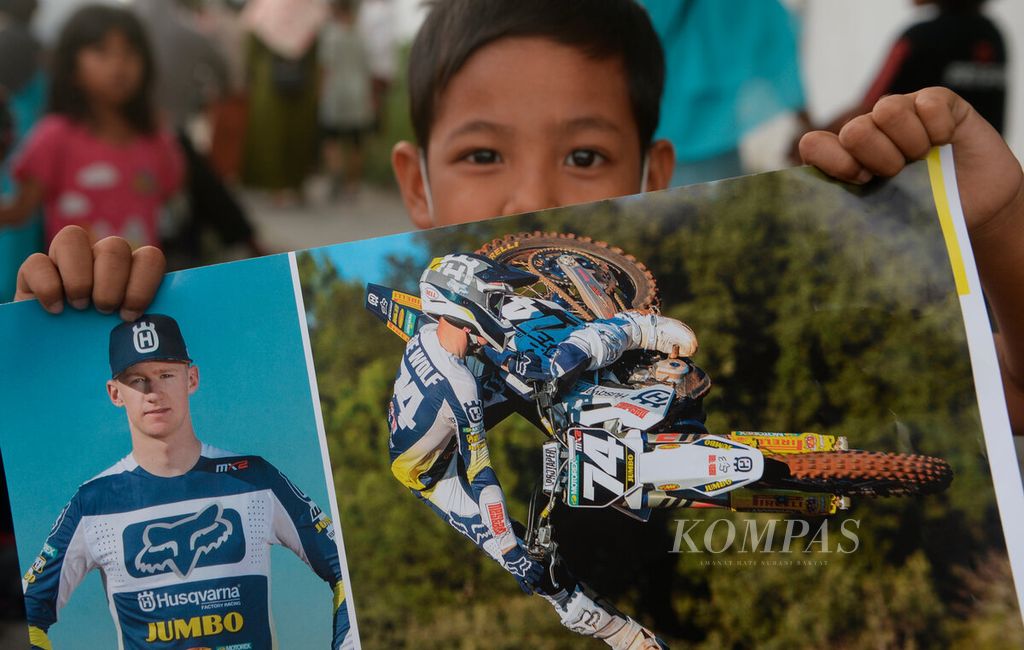 Anak-anak membawa poster salah satu pebalap yang mengikuti ajang Motorcross Grand Prix (MXGP) di Samota, Kabupaten Sumbawa, Provinsi Nusa Tenggara Barat, Jumat (24/6/2022). 