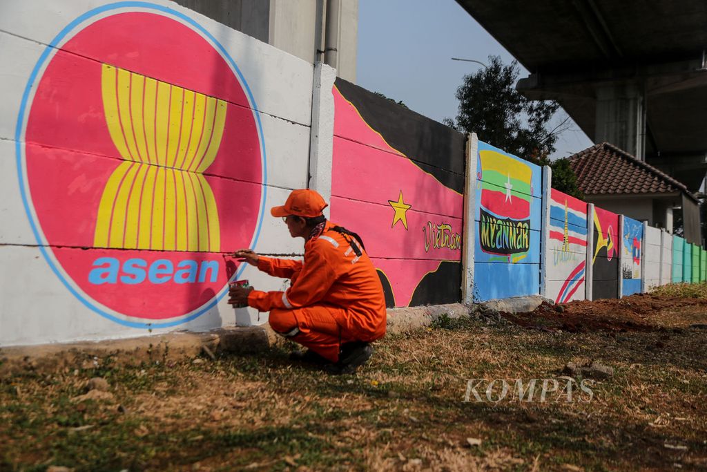 Petugas penanganan prasarana dan sarana umum menyelesaikan pekerjaannya di Jalan Taman Mini I, Pinang Ranti, Jakarta Timur, Rabu (30/8/2023). Pemerintah Kota Jakarta Timur mempercantik sejumlah tembok untuk menyambut Konferensi Tingkat Tinggi ASEAN.