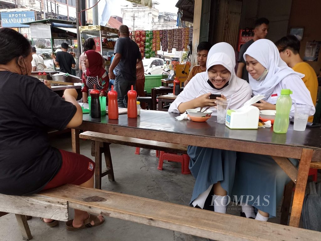 Siswi SMA beraktivitas di sebuah rumah makan di Jalan Iskandar Muda, Medan, Sumatera Utara, awal Agustus 2022.  