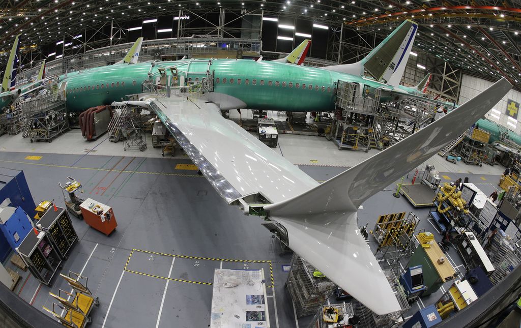 A worker passes by a Boeing 737 MAX 8 being assembled at the Renton factory, Washington, USA, on March 27, 2019.