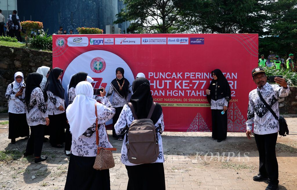 Para guru berfoto dengan latar tulisan peringatan HUT Ke-77 Persatuan Guru Republik Indonesia di Marina, Kota Semarang, Jawa Tengah, Sabtu (3/12/2022). 