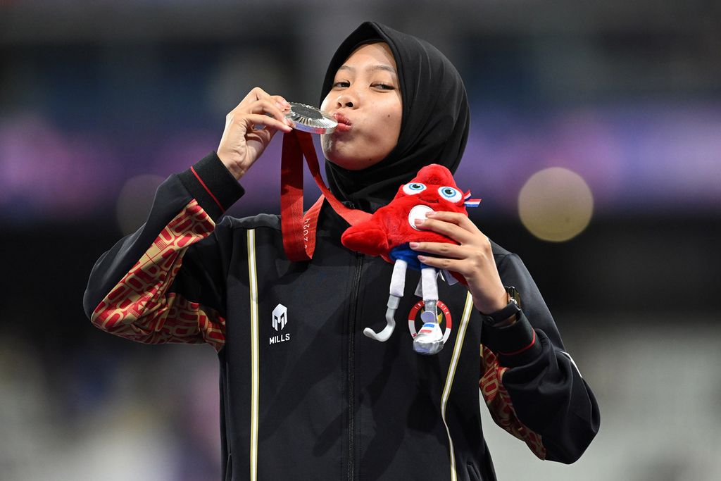 Sprinter Indonesia, Karisma Evi Tiarani, mencium medali yang diperoleh dari final nomor 100 meter T63 putri Paralimpiade Paris 2024 di Stadion Stade de France, Paris, Perancis, Sabtu (7/9/2024). Evi berhasil finis di urutan kedua dan berhak atas medali perak dengan catatan waktu 14,26 detik.