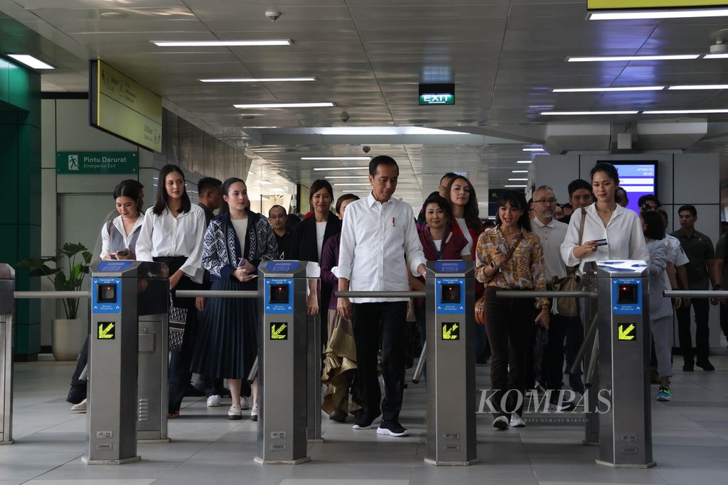 Presiden Joko Widodo menempelkan kartu uang elektronik untuk melintasi gerbang sebelum menaiki LRT dari Stasiun Jatimulya, Bekasi, Jawa Barat, Kamis (10/8/2023). Dalam uji coba yang berakhir di Stasiun Dukuh Atas, Jakarta, Presiden mengajak belasan artis.