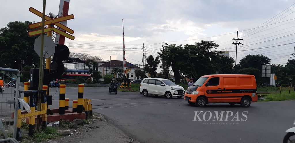 Sejumlah pengendara sepeda motor dan mobil melintas di pelintasan sebidang kereta api di dekat Stasiun Waru, Sidoarjo, Jawa Timur, Kamis (5/1/2023). Pelintasan sebidang merupakan salah satu lokasi rawan kecelakan lalu lintas.