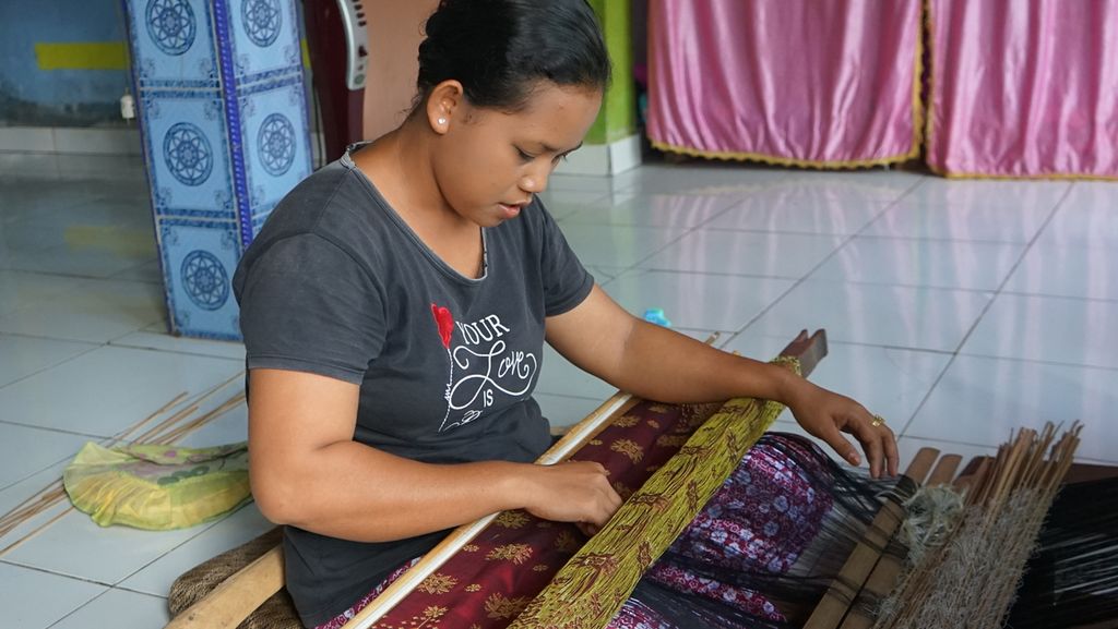 Seorang petenun di Desa Muara Penimbung, Kecamatan Indralaya, Kabupaten Ogan Ilir, menenun songket di rumahnya, Kamis (10/3/2022). Kawasan ini dijuluki kampung songket karena penduduknya memiliki kemampuan membuat songket.
