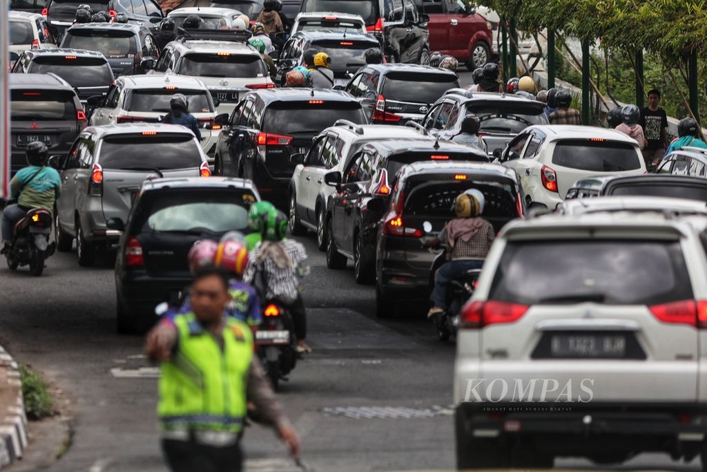 Polisi mengatur arus lalu lintas yang mengarah ke Jalan Malioboro di Jembatan Kewek, Kotabaru, Yogyakarta, Senin (1/1/2024). Pengalihan arus lalu lintas harus dilakukan seiring padatnya kendaraan wisatawan yang hendak melintasi Jalan Malioboro.