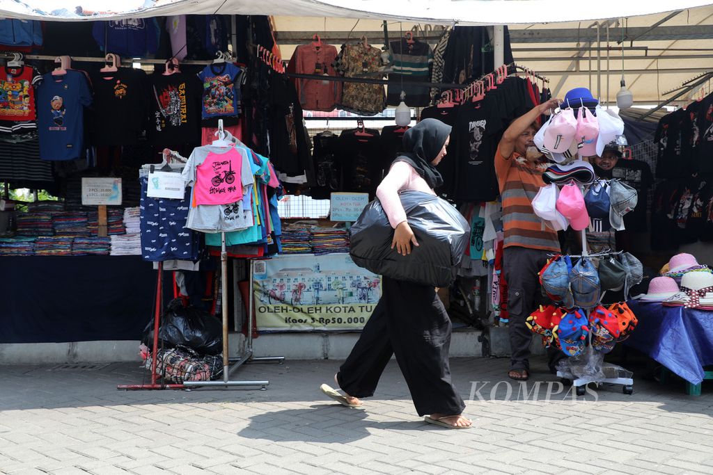 Pedagang kaki lima membawa barang dagangannya untuk dijajakan di kios Kota Intan, Taman Sari, Jakarta Barat, Selasa (12/7/2022). 