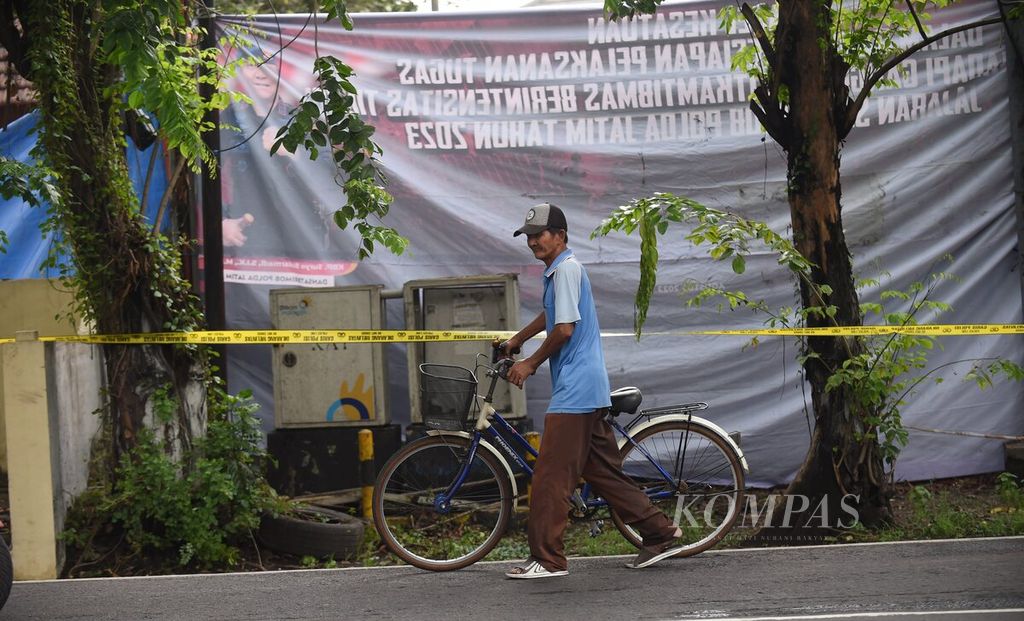 Warga melintas di bagian depan markas Detasemen Gegana Satuan Brimob Polda Jawa Timur yang telah ditutupi terpal pascaledakan di Jalan Gresik, Surabaya, Senin (4/3/2024). 