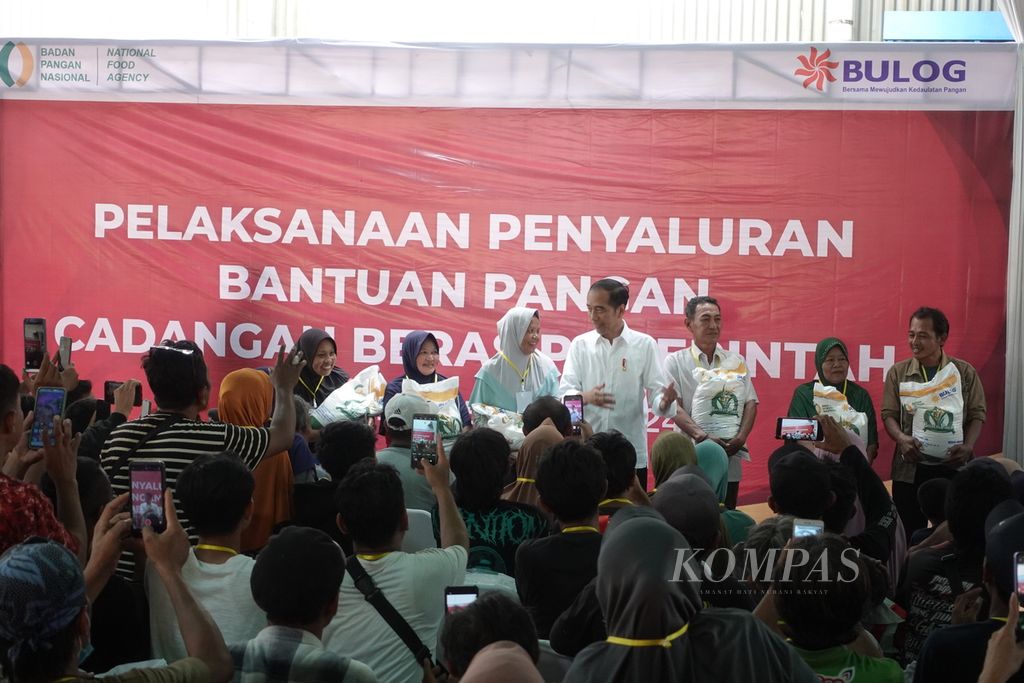 Presiden Joko Widodo saat menyerahkan bantuan beras cadangan pangan pemerintah kepada keluarga penerima manfaat di Gudang Bulog, Cibitung, Kabupaten Bekasi, Jawa Barat, Jumat (16/2/2024).