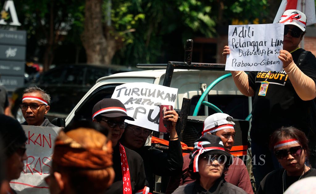 Peserta aksi membawa poster berisi tuntutan  terkait Pemilu 2024 di depan kantor KPU Jawa Tengah di Kota Semarang, Rabu (21/2/2024). 
