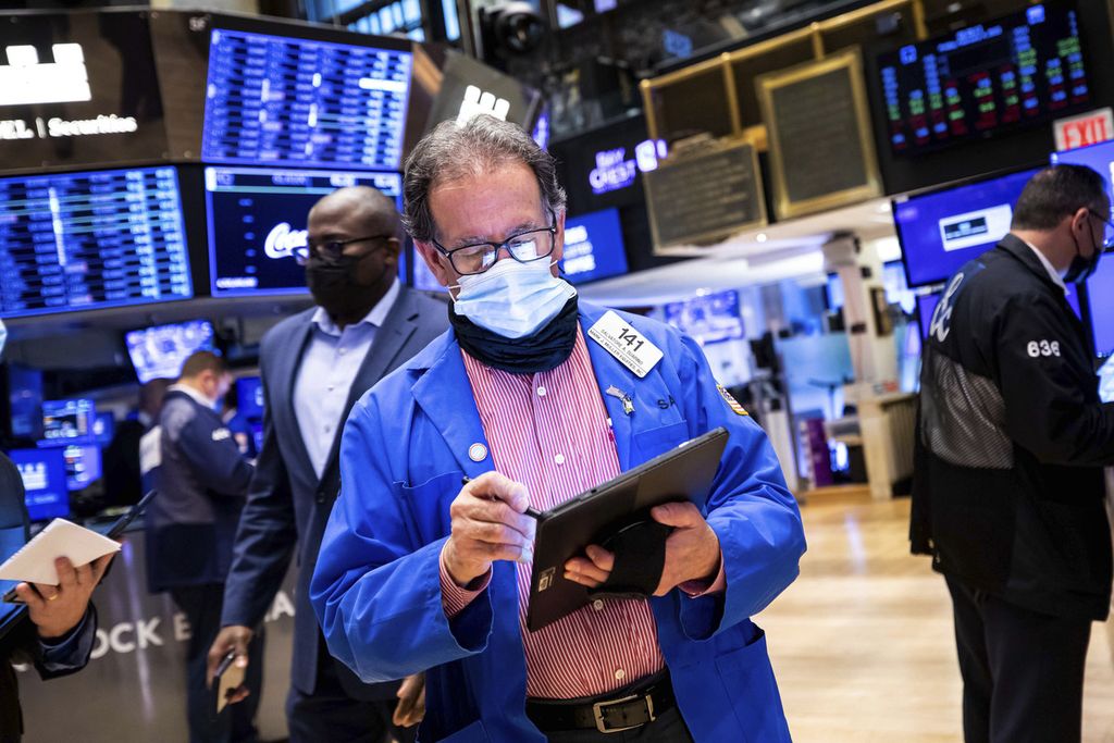 Dalam foto yang disediakan oleh New York Stock Exchange tampak seorang pialang, Sal Suarino (tengah) sedang bekerja di lantai bursa pada Jumat (4/2/2022). 
